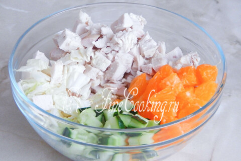 Курица, мандарины, огурец и капуста, соединённые в миске