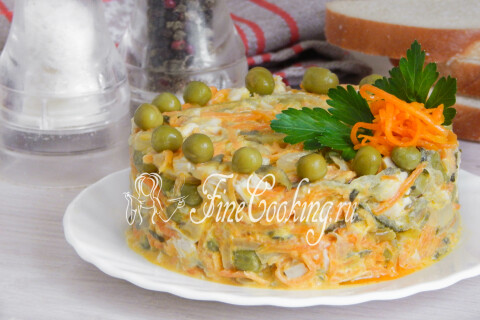 Слоями выложенные лук, морковь, огурцы и курица со сметаной на тарелке