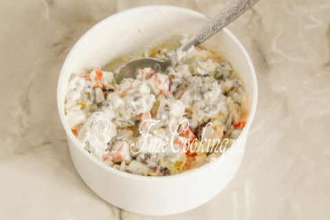 Готовый салат с куриной грудкой и грибами в салатнице на столе