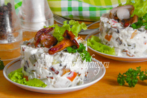 Салат с куриной грудкой и грибами, разложенный по тарелкам для подачи