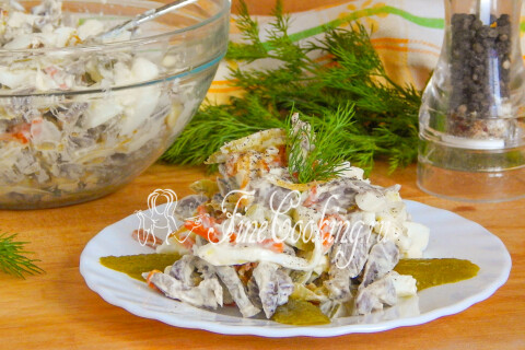 Салат с куриными желудочками на тарелке, приперченный по вкусу