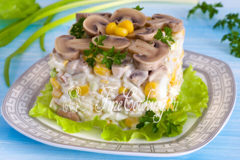 Салат с шампиньонами и кукурузой в порционной форме на тарелке