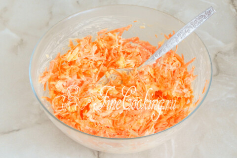 Готовый салат с морковью, сыром и чесноком, перемешанный в миске.