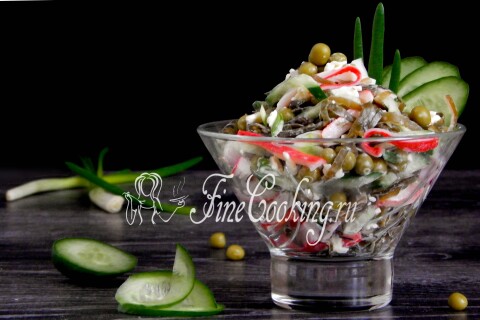 Готовый салат с морской капустой и горошком крупным планом в тарелке