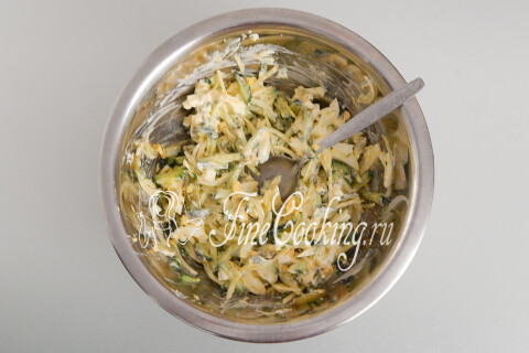 Перемешанный салат с майонезом, огурцами, луком, яйцами и петрушкой.