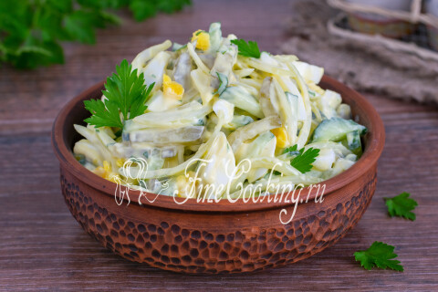 Салат с огурцами и яйцами в тарелке, украшенный зеленью петрушки.