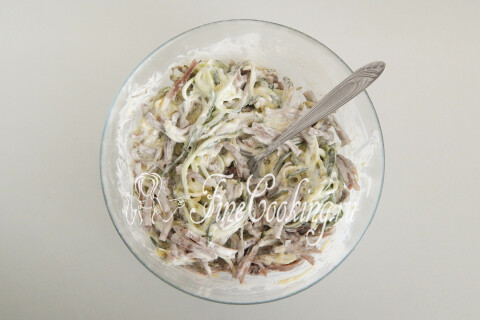 Салат с языком и огурцами, перемешанный в глубокой миске
