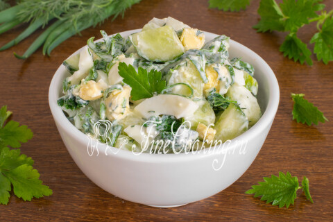 Салат с огурцом, яйцом и крапивой на тарелке