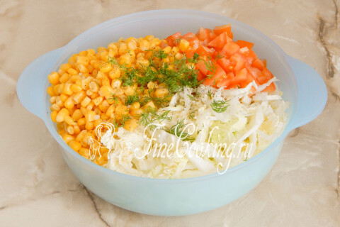 Рубленый укроп в миске с капустой, помидорами и кукурузой