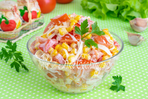 Готовый салат с помидорами, кукурузой и сыром на столе