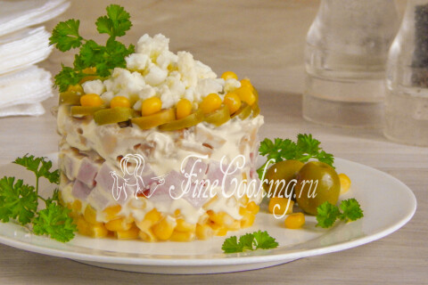Салат с ветчиной, шампиньонами и кукурузой, поданный слоями с веточкой петрушки
