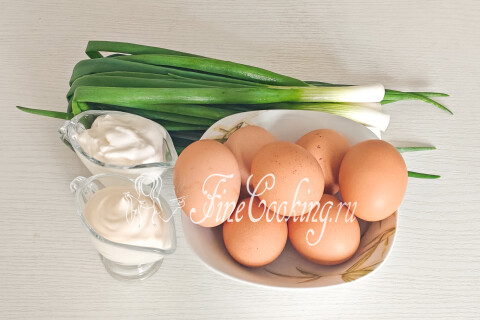 Продукты для салата с яйцом и луком: яйца, зелёный лук, сметана и майонез.