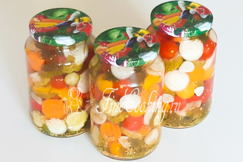 Остывшие банки с маринованным овощным ассорти на кухонном столе.
