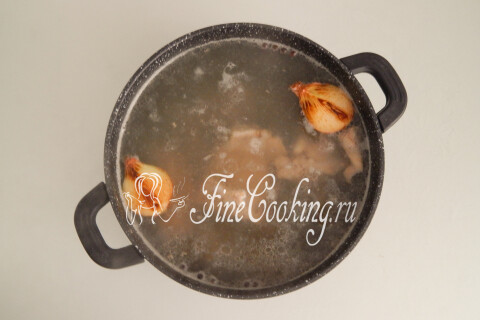 Опалённая на сковороде луковица в кастрюле с бульоном и мясом