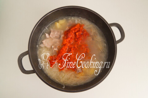 Зажарка из лука, моркови и томатной пасты в кастрюле со щами.