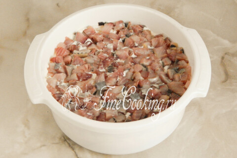 Верхний слой из кусочков солёной сельди, слегка прижатый рукой