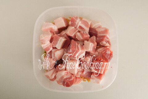 Кусочки свиной грудинки, переложенные в миску к маринованному луку