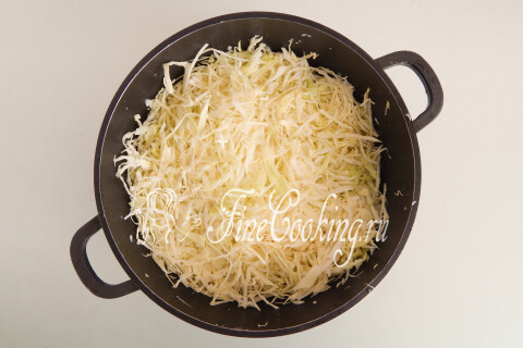 Капуста с солью и сахаром, размятая руками в кастрюле