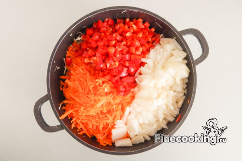Кастрюля с нашинкованной капустой и добавленными к ней овощами