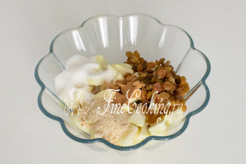 Яблоки в миске с сахаром, изюмом, панировочными сухарями и корицей