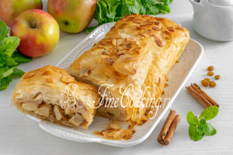 Тёплый штрудель с яблоками, нарезанный порционными кусочками, на тарелке