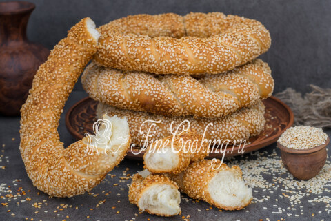 Симиты готовые, обсыпанные кунжутом, на разделочной доске.