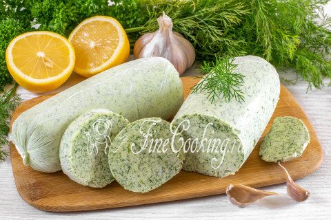 Ломтики зелёного сливочного масла с укропом и чесноком на кусочках хлеба.