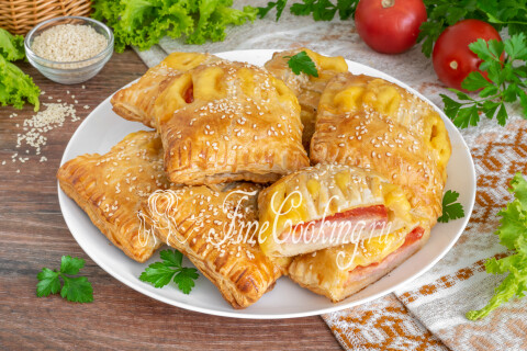 Хрустящие слойки с ветчиной, сыром и помидорами на тарелке.