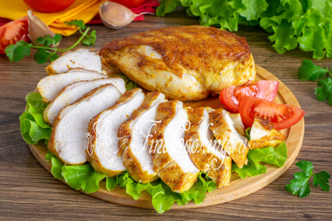 Нарезанная сочная куриная грудка с гарниром на тарелке