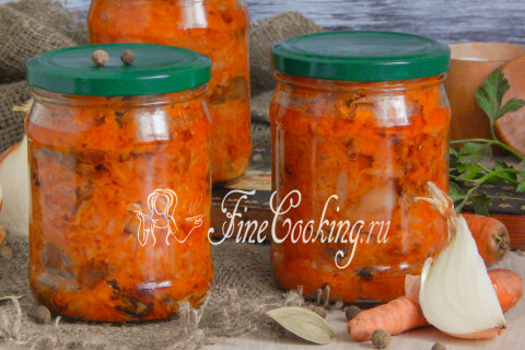 Банки с солянкой из тушёной капусты, моркови, лука и грибов на столе.