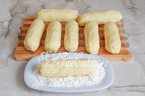 Картофельные заготовки с сосисками обваливаются в пшеничной муке.