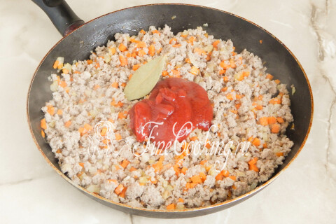 Томатная паста и лавровый лист добавлены к обжаренному мясу с овощами.