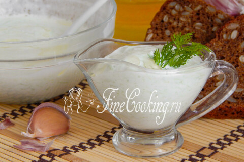 Ложка, зачерпывающая густой соус со дна глубокой миски