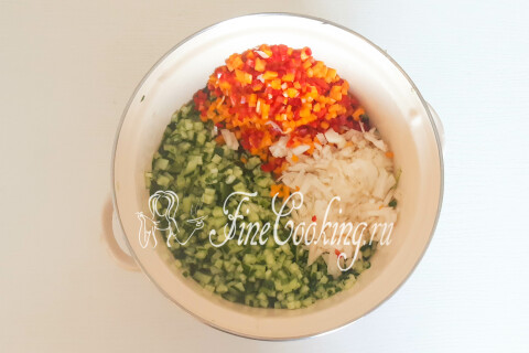 Кастрюля с нарезанными кубиками огурцов, перца и лука.