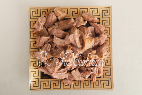 Отварная говядина, нарезанная крупными кусками, на разделочной доске