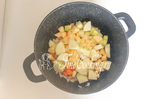 Кабачок, картофель и зубок чеснока, нарезанные кусочками, в кастрюле.