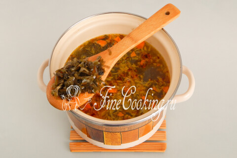 Морская капуста всыпана в кастрюлю с супом и овощами.