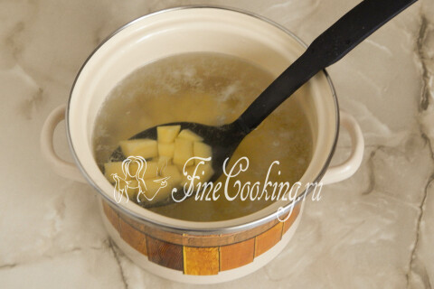 Нарезанный кубиками картофель, опущенный в кипящую воду кастрюли