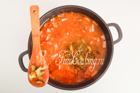 Солёные огурцы с рассолом, отправленные в кастрюлю к остальным продуктам.