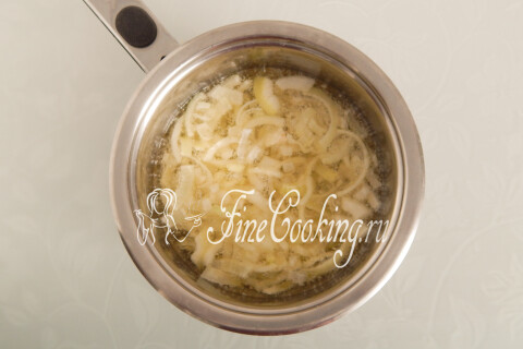 Узкая кастрюлька с кипящим маслом и опущенными в него кусочками лука.