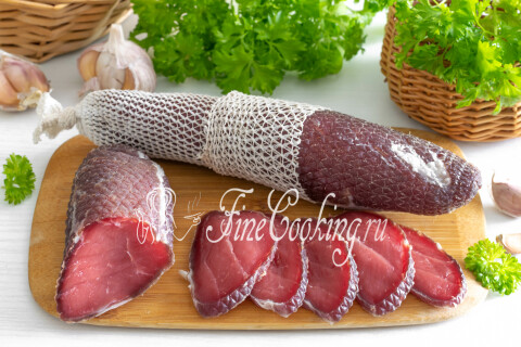 Нарезанная ломтиками сыровяленая свиная вырезка на тарелке