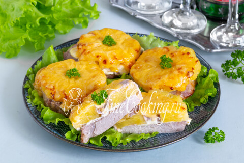 Свинина с ананасами и расплавленным сыром на тарелке