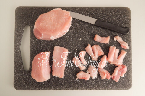 Свиная корейка, нарезанная некрупными брусочками, на разделочной доске.