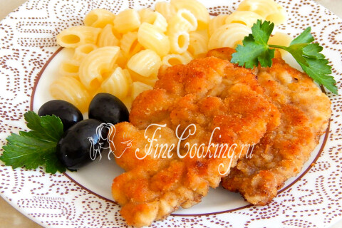 Свиные отбивные на тарелке рядом с макаронами