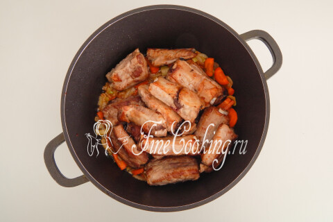 Свиные ребрышки с овощами, тушащиеся под крышкой в кастрюле