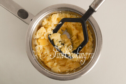 Горячий картофель, размятый толкушкой в кастрюле.