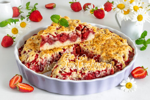 Остывший тёртый пирог с клубникой нарезан порционными кусочками