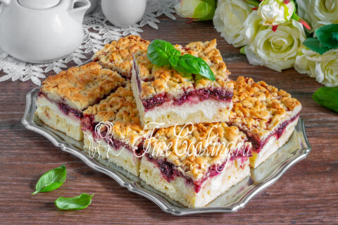 Порционные кусочки тёртого пирога с творогом и вареньем на столе.