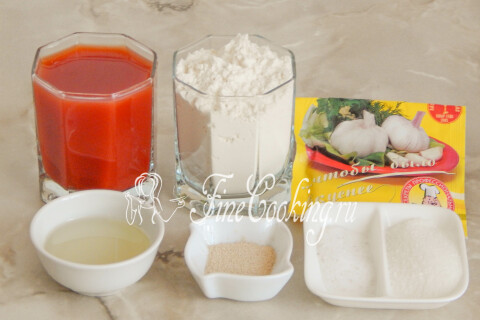 Продукты для томатного хлеба: томатный сок, мука, чеснок и дрожжи