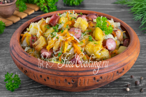 Тушёная капуста с баклажанами и копчёными колбасками на тарелке